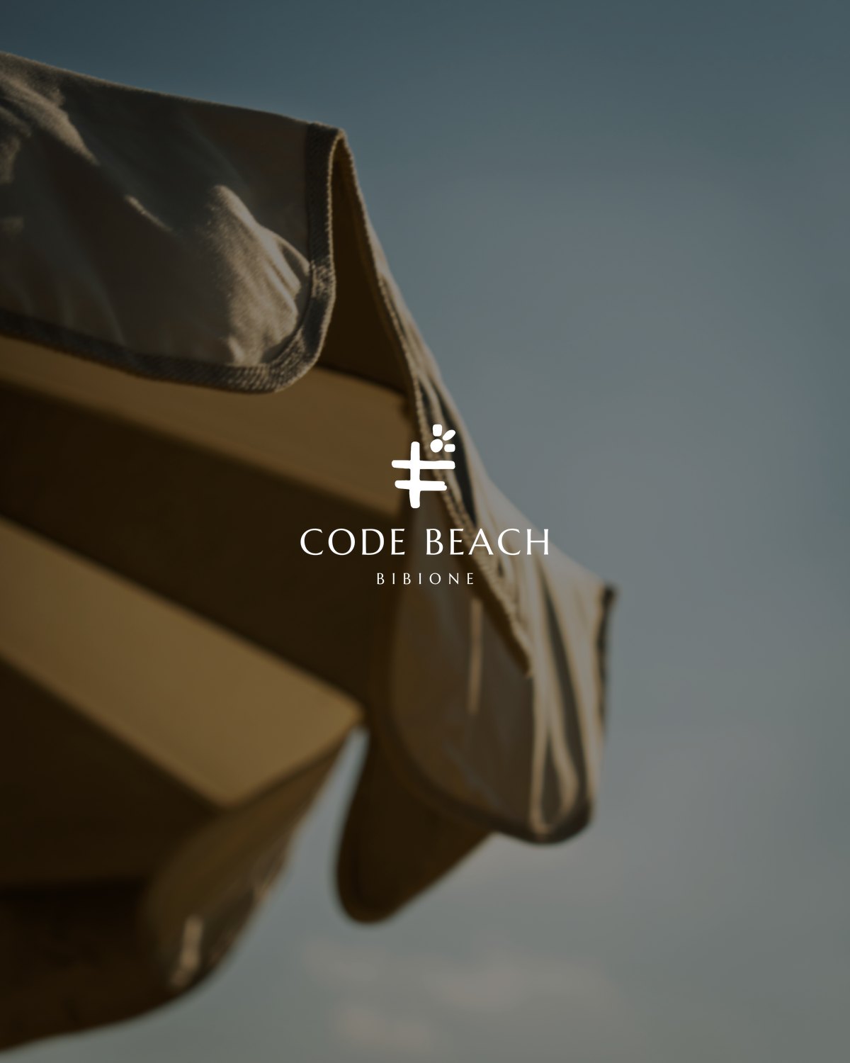 Il marchio Code Beach Bibione applicato su una fotografia della spiaggia
